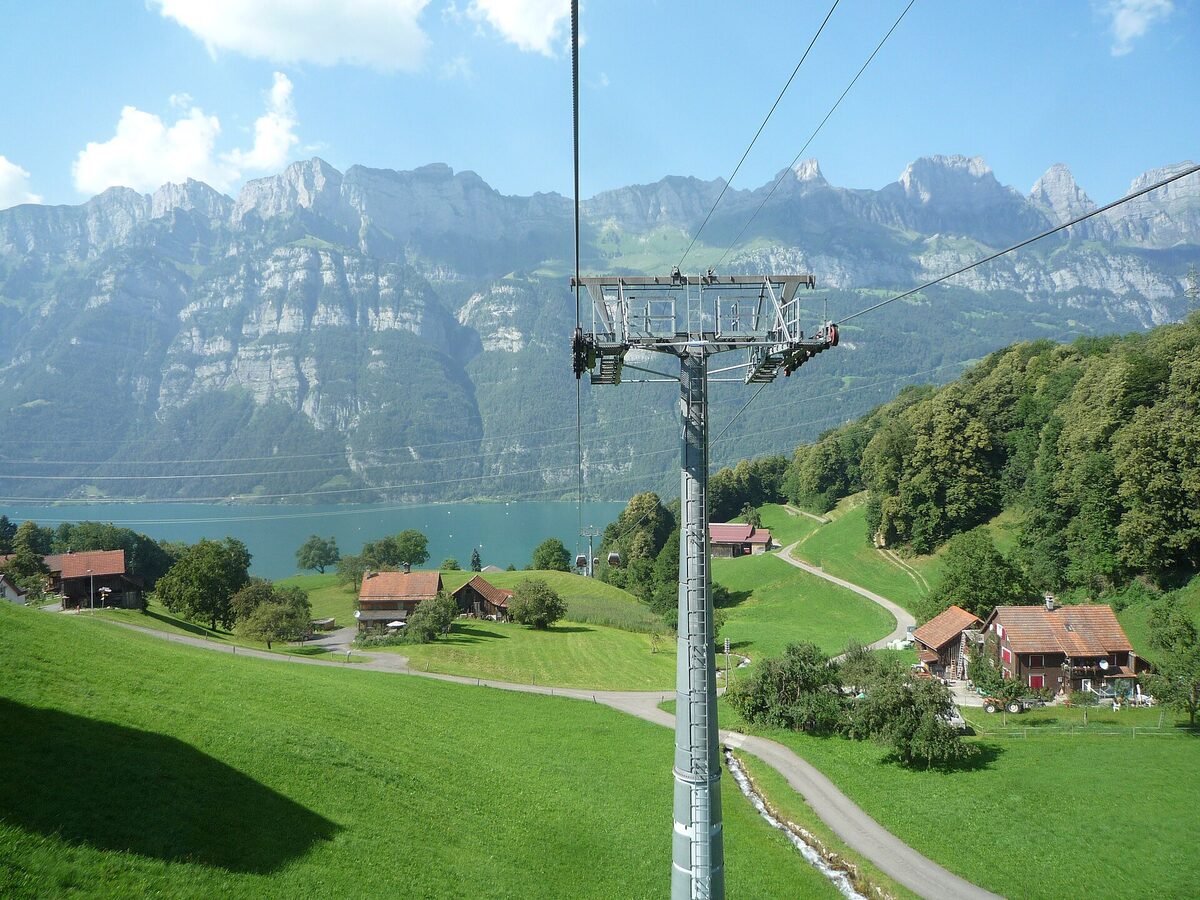 Gondel der Bahn Unterterzen–Flumserberg über Wiesen, im Hintergrund der Walensee